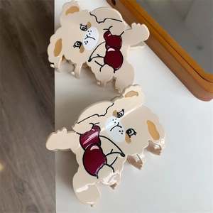 Close-up of beige cherry rabbit hair claws with cartoon figure design on white surface