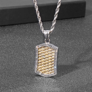 Close-up of punk style silver and gold dog tag pendant with inlaid zircons and twist chain