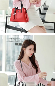 Détail du sac à main en cuir rouge avec anses noires et pendentif en cœur