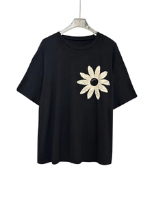 Detail of delicate white daisy embroidery on soft black slim-fit cotton t-shirt