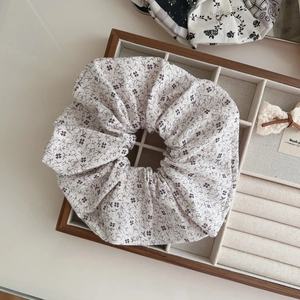 Detailed close-up of floral scrunchie on a wooden jewelry box for daily hair styling