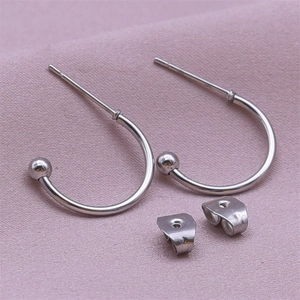 Detail of 304 stainless steel C-shape silver earrings with spherical end and butterfly backs