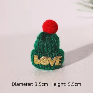 Detailed view of mini green knitted Christmas hat with LOVE text and red pompom, 5.5cm tall
