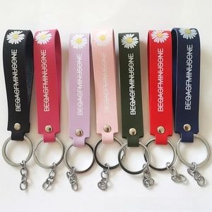 Close-up of colorful PU leather keychains with daisy prints and silver metal rings