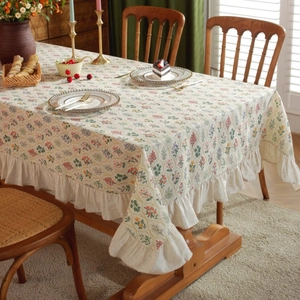 Close-up of floral rectangular tablecloth with ruffle edges in a cozy dining setting