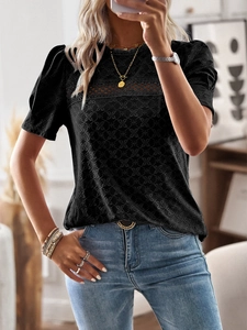 Detail of black short sleeve top with delicate embroidery and lace patchwork design