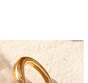 Close-up of a 18K gold plated irregular fluid ring with organic polished texture