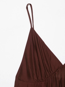 Detailed close-up of delicate spaghetti straps and ruched V-neckline on dark brown dress