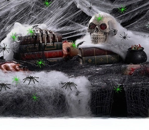 Halloween prop setup with fake skull, severed hand, spider webs, and small spiders