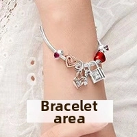 Silver beaded bracelet featuring red heart and rose gold lock charms worn on wrist