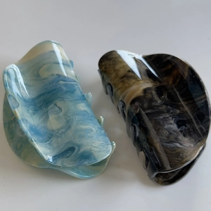Detail of marble pattern hair claw clips with gold foil glitter in blue and brown