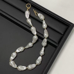 Baroque irregular pearl necklace with gold OT toggle clasp on black display board