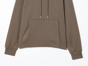 Detailed macro view of brown hoodie showing ribbed hem and kangaroo pocket fabric texture