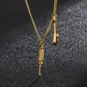 Gold mini tool pendant necklace featuring a screwdriver and wrench on a textured surface