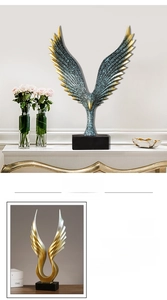 Close-up of hand-painted resin angel wings decor with golden edges and feather texture