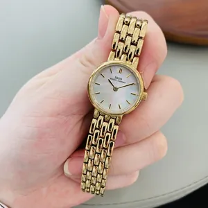 Elegant gold metal mesh watch for women featuring a minimalist pearl shell dial