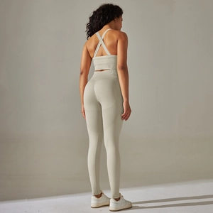 Detail von Cross-Back Yoga-Bra und nahtlosen High-Waist-Leggings im cremefarbenen Set