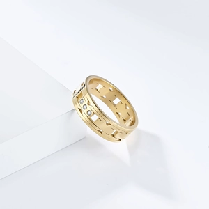 Close-up of gold titanium ring with geometric cut-outs and inlaid diamonds