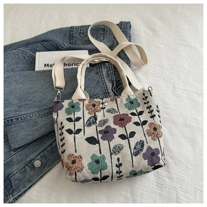 Detail of canvas tote bag with floral print, dual handles and adjustable shoulder strap
