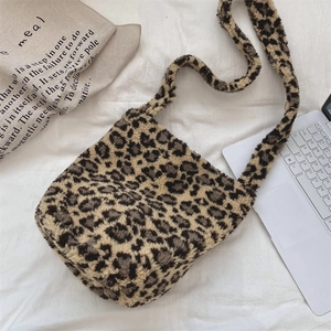 Detail of leopard print plush crossbody bag showing soft faux fur texture and wide strap
