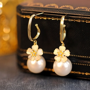 Close-up of pearl flower earrings with gold metal hook and cat eye stone petals