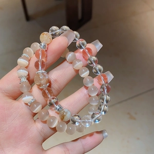 Détail de perles en cristal naturel avec effet œil-de-chat et entretoises en métal