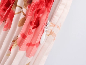 Detail shot of invisible white side zipper on pink floral pleated maxi dress fabric