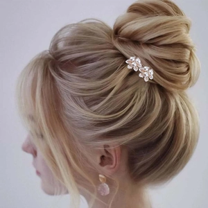 Détail des épingles à cheveux fleurs en perles sur chignon de mariée pour coiffure