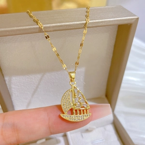 Macro shot of gold-plated sailboat pendant with sparkling cubic zirconia on a necklace