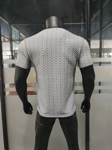 Détail du t-shirt de sport gris clair avec texture en nid d'abeille et coutures orange