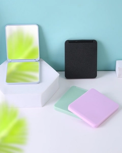 Macro view of portable folding makeup mirrors in multiple colors on a geometric platform