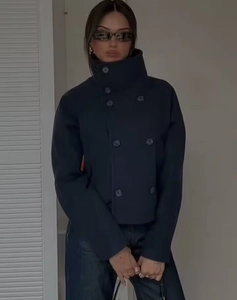 Detailed view of navy blue wool jacket featuring double-breasted buttons and high collar