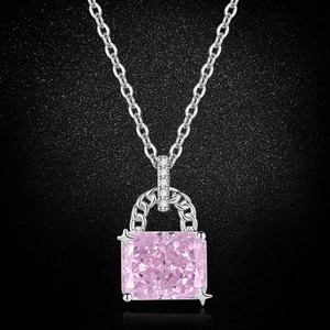 Close-up of pink sapphire pendant on silver O-chain against a black textured background