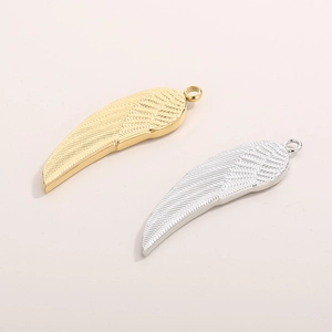 Detail view of gold and silver stainless steel wing pendants with fine feather textures