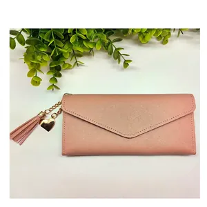 Portafoglio lungo rosa da donna con nappina a cuore e patta a busta in ecopelle
