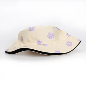 Nahaufnahme des beigen Sonnenhuts mit violetten Blumen und Smiley-Gesichtern