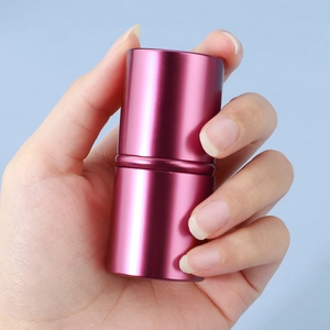 Close-up of a pink portable telescopic makeup brush held in hand for travel size