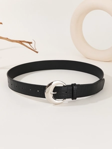 Detail of black crocodile pattern belt with silver semicircular buckle on beige background