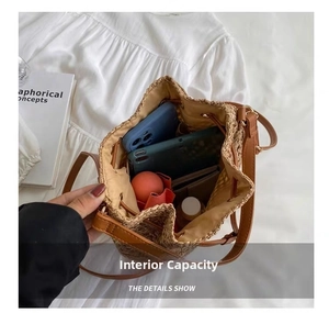 Top view of spacious interior of straw bucket bag holding phone, water bottle, and umbrella