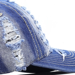Distressed blue denim baseball cap with vintage frayed holes and retro washed texture