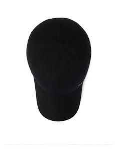 Detail view of winter baseball cap showing dark black textured fabric and metal logo accent