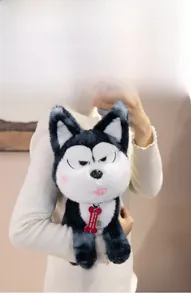 Close-up of a plush husky toy featuring a red bone tag in a cozy lifestyle setting