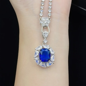 Macro view of blue gemstone necklace with silver diamond tennis chain on model skin