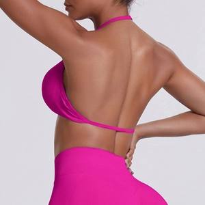 Detail of magenta halter sports bra showing open back design and seamless knit texture