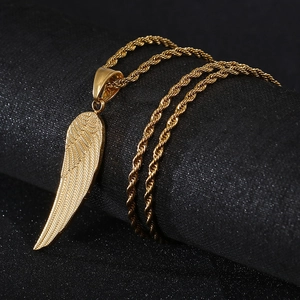 Golden angel wing pendant with twisted chain on a dark textured background