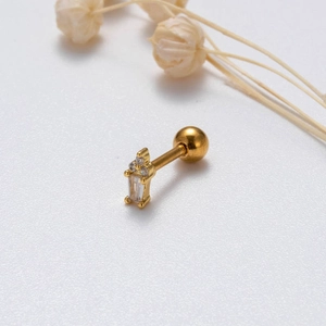 Macro view of a gold cross cartilage stud earring with micro-paved cubic zirconia