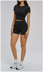 Close-up of black seamless short sleeve crop top and high-waisted fitness biker shorts