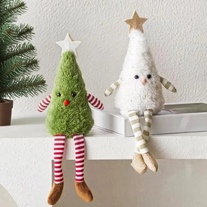 Close-up of plush Christmas tree dolls with striped long legs sitting on a white mantel