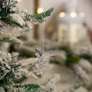 Clear acrylic angel ornament with silver wings hanging on a snowy Christmas tree branch