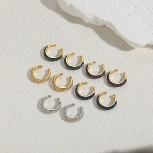 Macro shot of assorted gold and silver ear cuffs with colorful micro-pave zircons